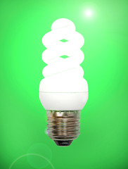 Energy save lamp on green background.