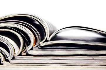 Pile of magazines with open pages on a white background