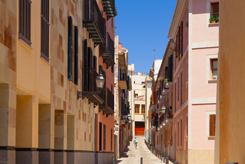 Narrow street in the old town with a person silhouette in the end