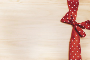 Red bow in peas on a wooden background/red bow on a wooden background