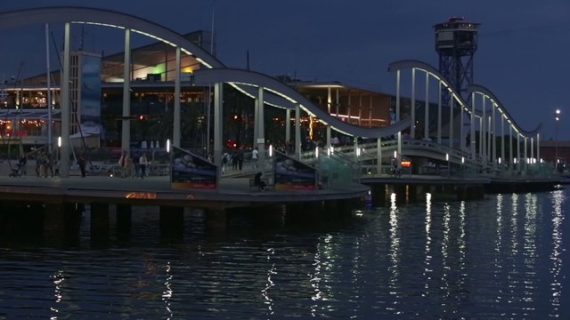 Night view of Rambla de Mar, footbridge modern design in the port of Barcelona, a must for visitors to walk into town.Time Lapse