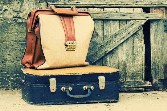 Old retro suitcases on wooden grunge a background.