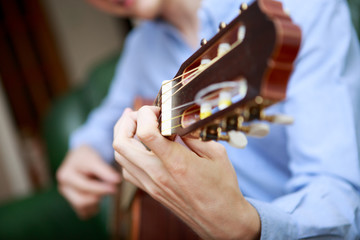 Young musician playing at acoustic guitar