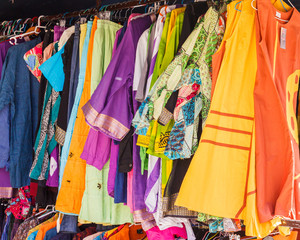 Ropas alegres / Vestidos de colores brillantes colgados en un mercadillo