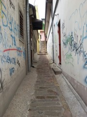 Narrow street with grafitti on walls