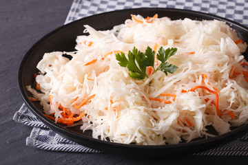 sauerkraut and carrots in a black plate close-up horizontal
