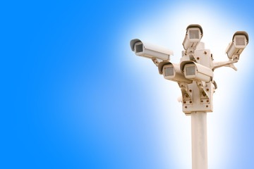 Multiple surveillance cameras on blue sky