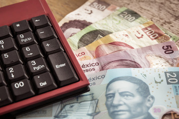 money, coins and bills mexican pesos over a wooden table
