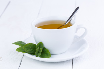Tasty mint tea on wooden table.