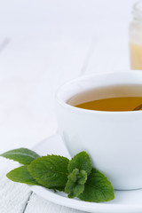 Mint tea with honey on wooden table.