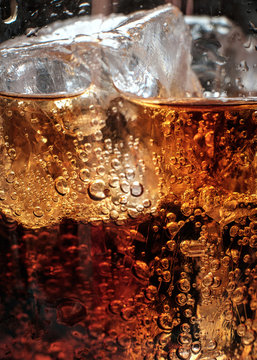 Bubbles in the glass of cola with ice.