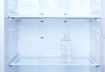 Single bottle of water in refrigerator close up