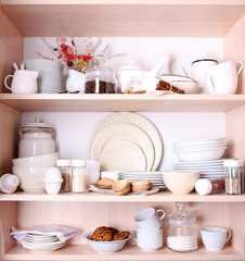 Fototapeta na wymiar Kitchen utensils and tableware on shelves