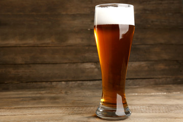 Glass of beer on wooden background