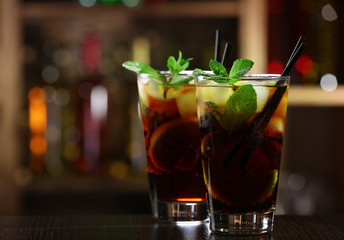 Glass of cocktail in bar on bright blurred background