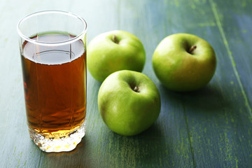 Glass of healthy fresh juice of apples on wooden background