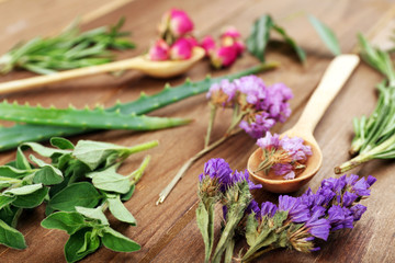 Obraz na płótnie Canvas Green herbs and leaves on wooden table, closeup