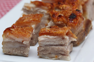 Delicious roasted pork belly cubes on white plate