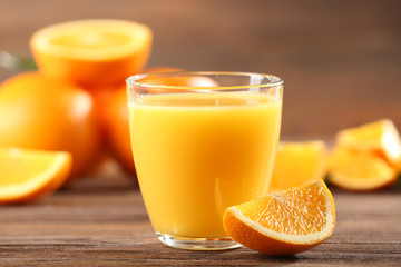 Orange juice on table on wooden background