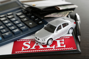 Tablet, calculator and toy car on table close-up