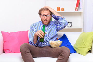 Unhappy man holding his head on the sofa