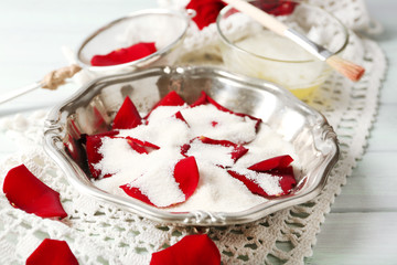 Making candied rose flower petals with egg whites and sugar, on wooden background