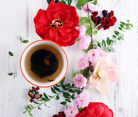 Cup of tea with beautiful flowers on wooden background