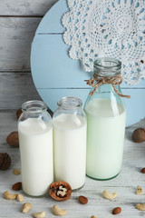 Milk in glassware and walnuts on wooden background