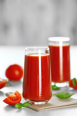 Fototapeta na wymiar Tomato juice and fresh tomatoes on wooden table close-up