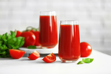 Tomato juice and fresh tomatoes on wooden table close-up
