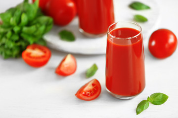 Tomato juice and fresh tomatoes on wooden table close-up