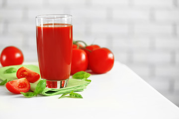 Tomato juice and fresh tomatoes on wooden table close-up