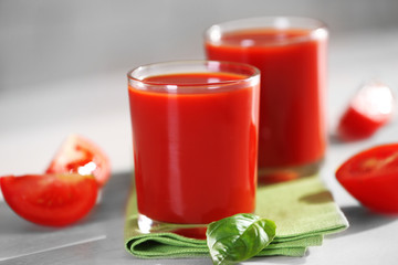 Tomato juice and fresh tomatoes on wooden table close-up