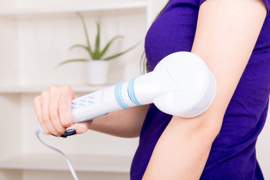 Woman massaging the body with infrared lamps massager