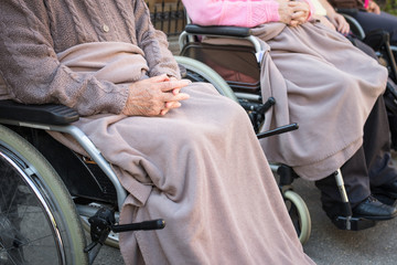 Old woman in the wheel chair. Close-up shot of her hands.