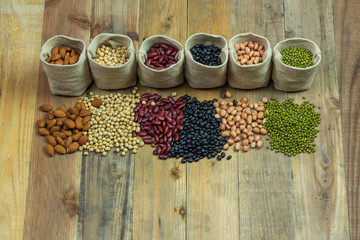Different kinds of beans scattered on wooden background