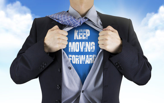 businessman showing Keep moving forward words underneath his shi