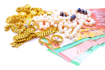 Collection of gold and pearl jewelery on Malaysia ringgit notes