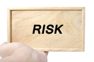 Business and financial concept. hand holding plain wood with word risk isolated white background
