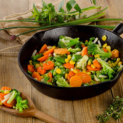 Stir fried vegetables in  iron skillet .