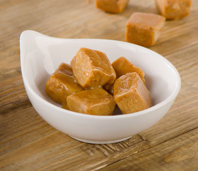 Caramel candies  on a rustic wooden table.