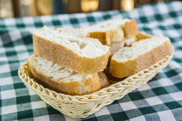 Fototapeta na wymiar background wicker basket with fresh bread on a checkered tablecloth