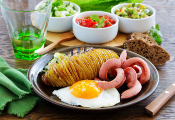 A hearty breakfast of baked potatoes (accordion), fried sausage, fried eggs