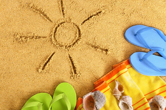 Summer sun drawing drawn on a sand beach with towel seashell and flip flop sandals happy relaxed vacation holiday photo