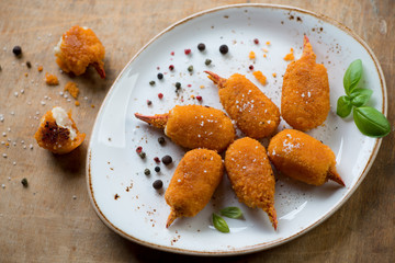 Above view of roasted breaded crab claws on a plate, studio shot