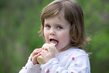 little girl eating an ice cream outdoors