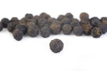 Black pepper seeds on white background