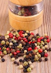 Pepper with mill on wooden background