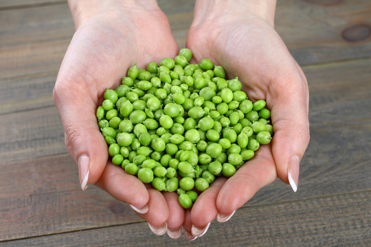 Woman holding fresh green peas