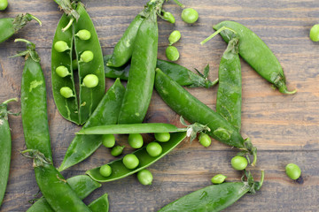Fresh green peas on a wooden background.